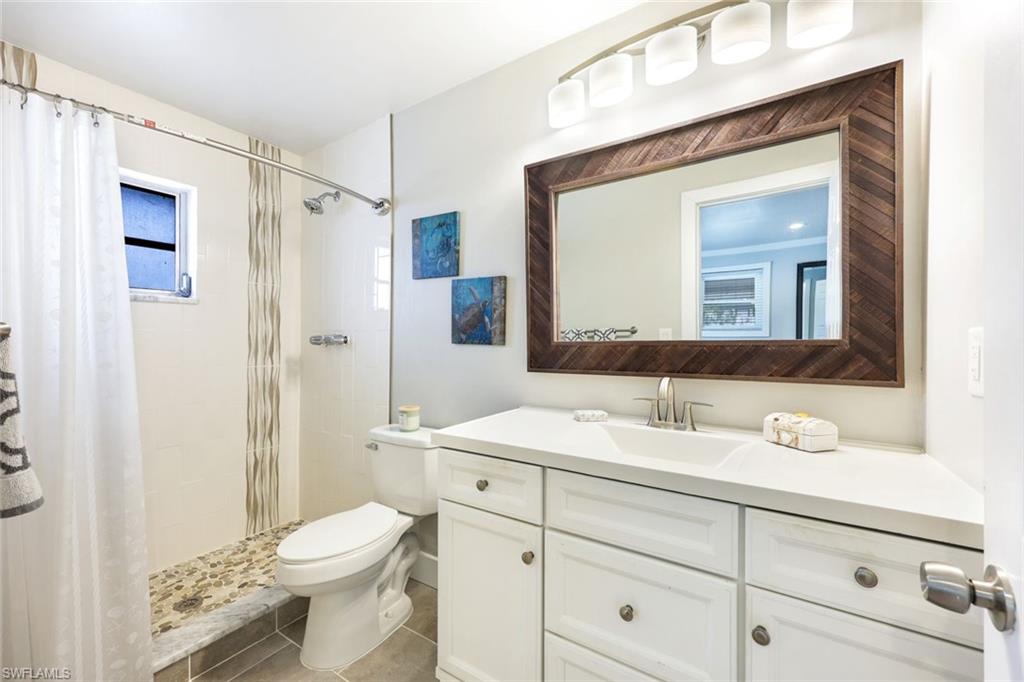 645 101st Avenue North Naples, FL 34108 - Photo 11 of 24 a bathroom with a sink vanity granite toilet and shower