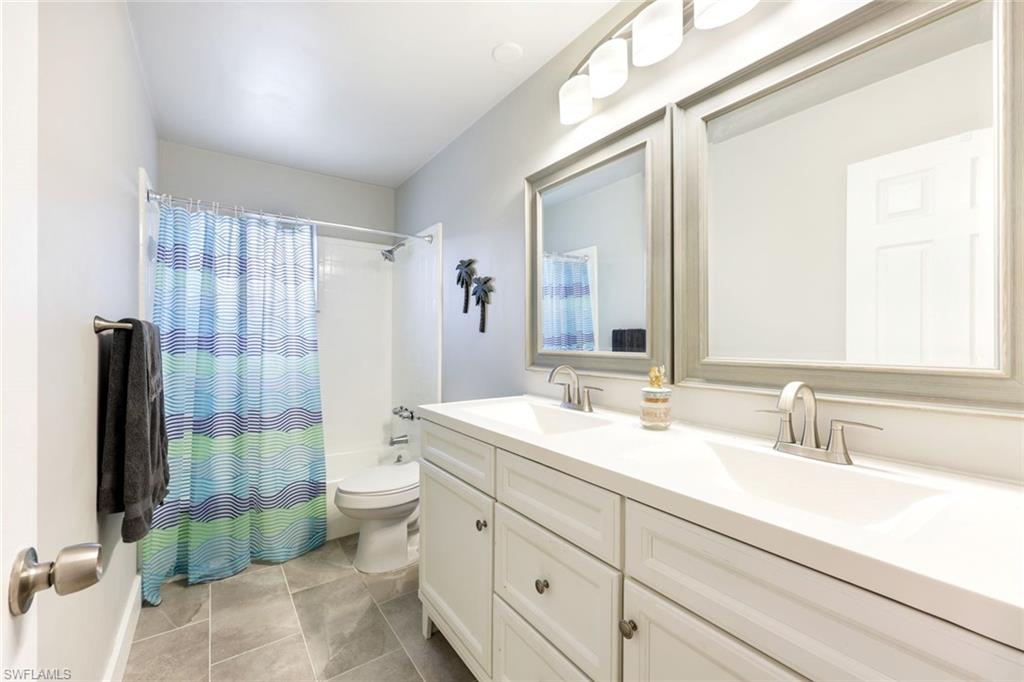 645 101st Avenue North Naples, FL 34108 - Photo 13 of 24 a bathroom with a double vanity sink toilet and shower