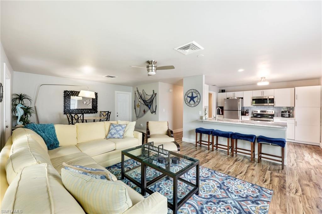 645 101st Avenue North Naples, FL 34108 - Photo 4 of 24 a living room with furniture wooden floor and a kitchen view