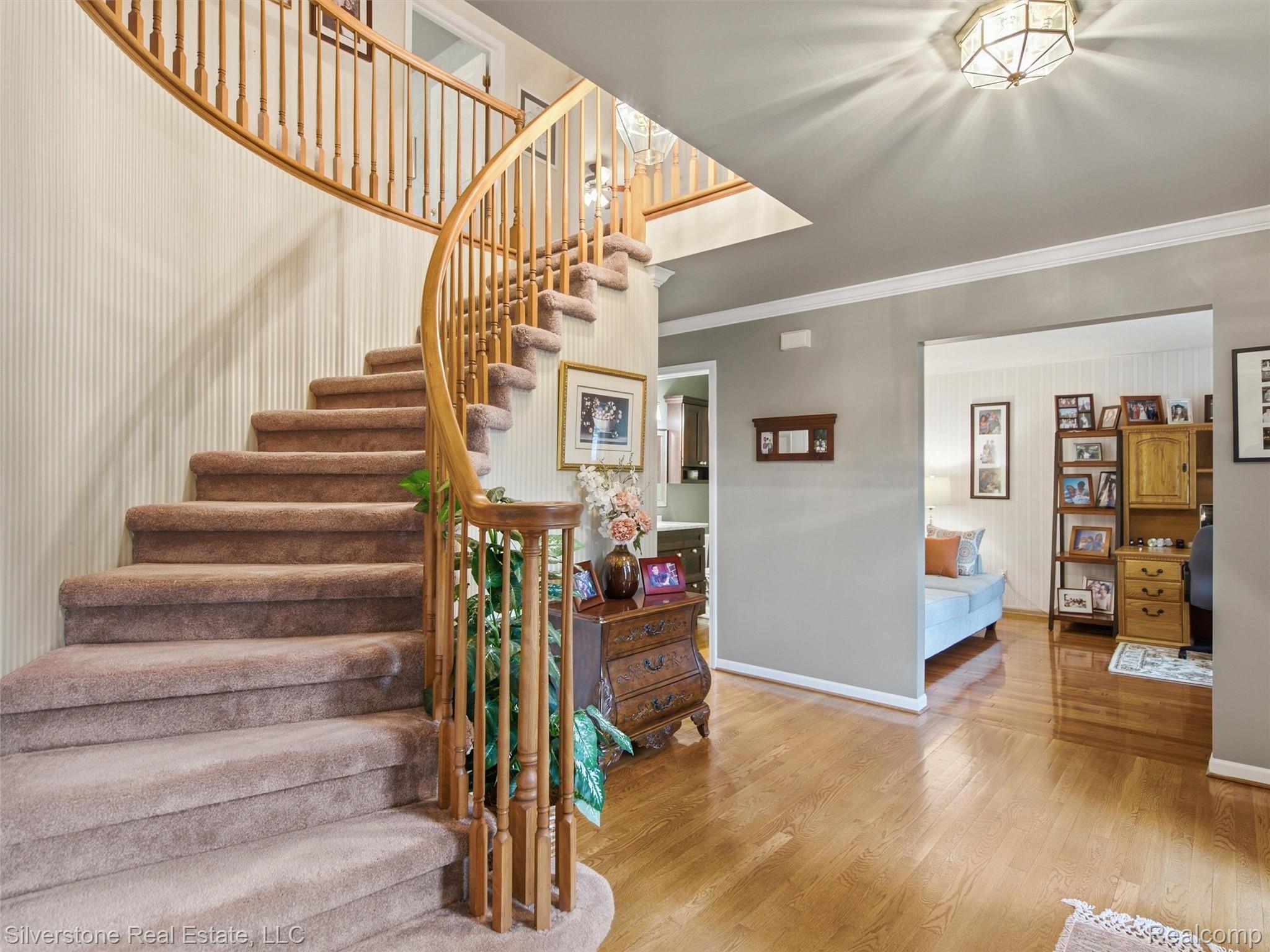 6577 Edith Court Troy, MI 48085 - Photo 10 of 61 Curved staircase featuring wood banister and carpeted treads