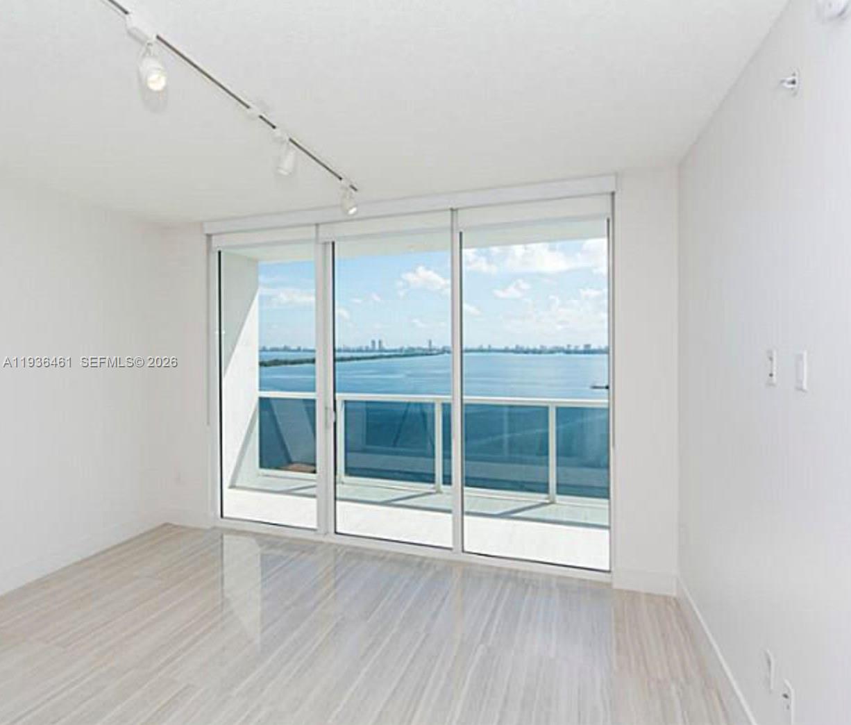 600 Northeast 27th Street, Unit 2004 Miami, FL 33137 - Photo 2 of 9 an empty room with wooden floor and windows