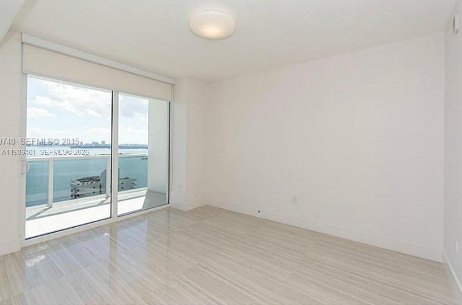 600 Northeast 27th Street, Unit 2004 Miami, FL 33137 - Photo 6 of 9 an empty room with wooden floor and windows