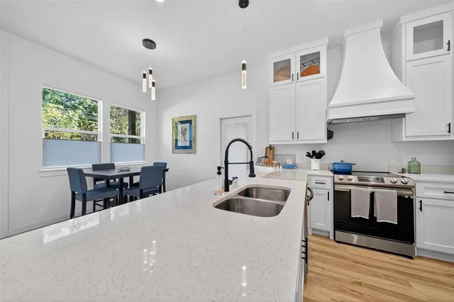 a kitchen with kitchen island a sink stove and wooden floor