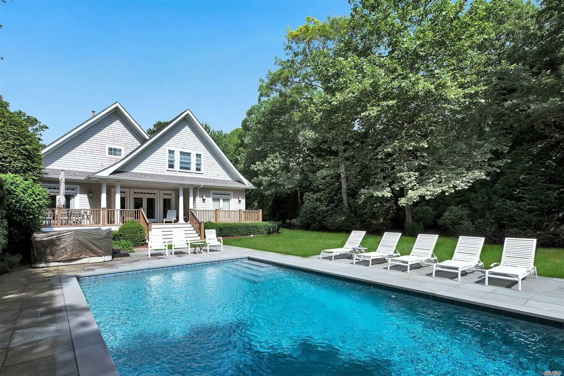 a front view of a house with swimming pool and a yard