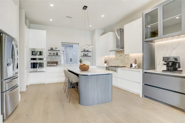 a kitchen with kitchen island a counter top space a stove a sink and a refrigerator