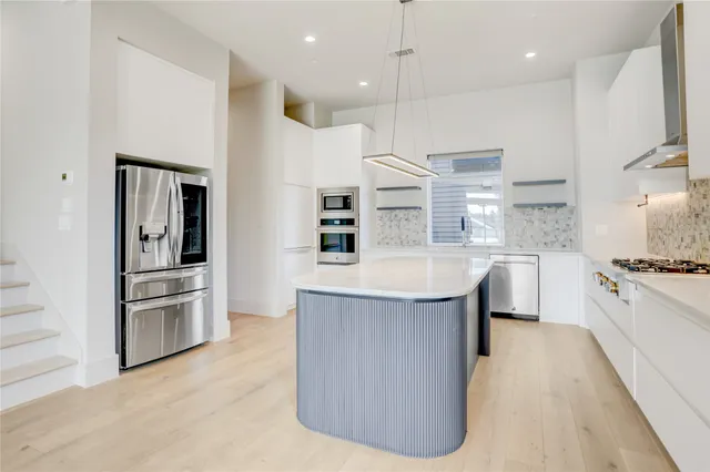 a kitchen with kitchen island a sink stainless steel appliances and window
