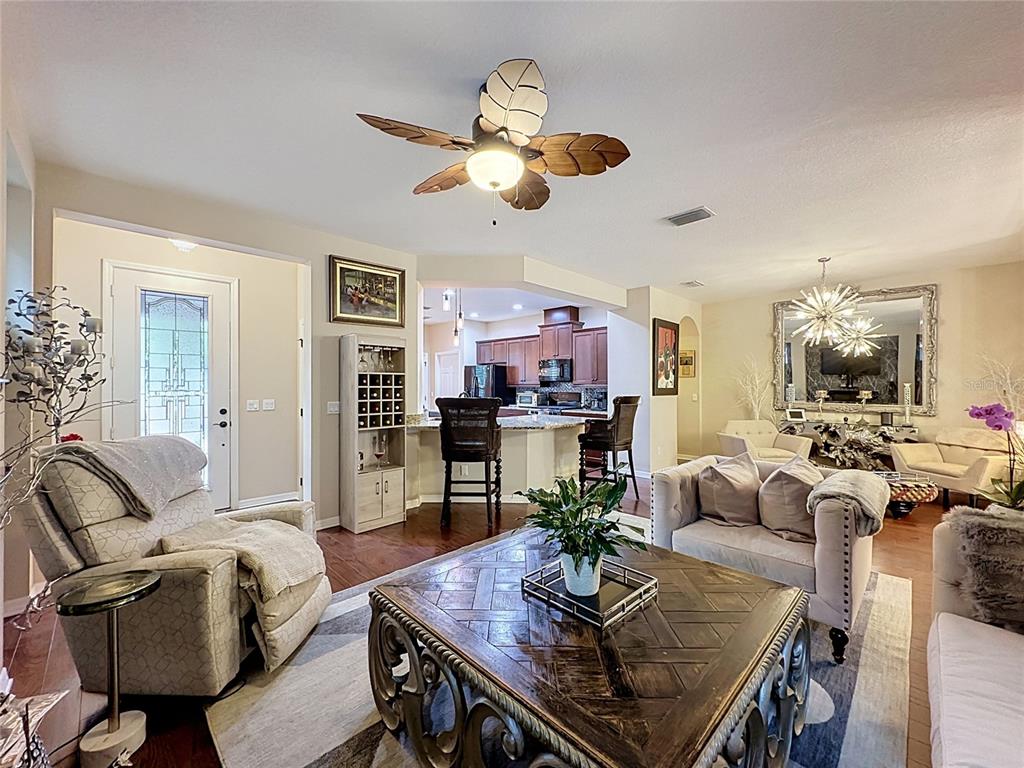 255 Silver Maple Road Groveland, FL 34736 - Photo 11 of 68 a living room with furniture kitchen view and a chandelier