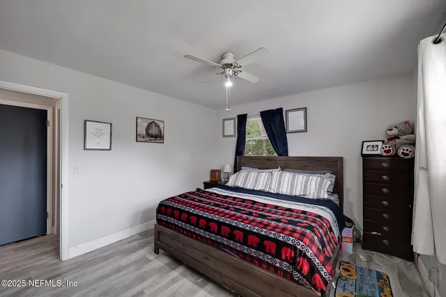 a bedroom with a bed and wooden floor
