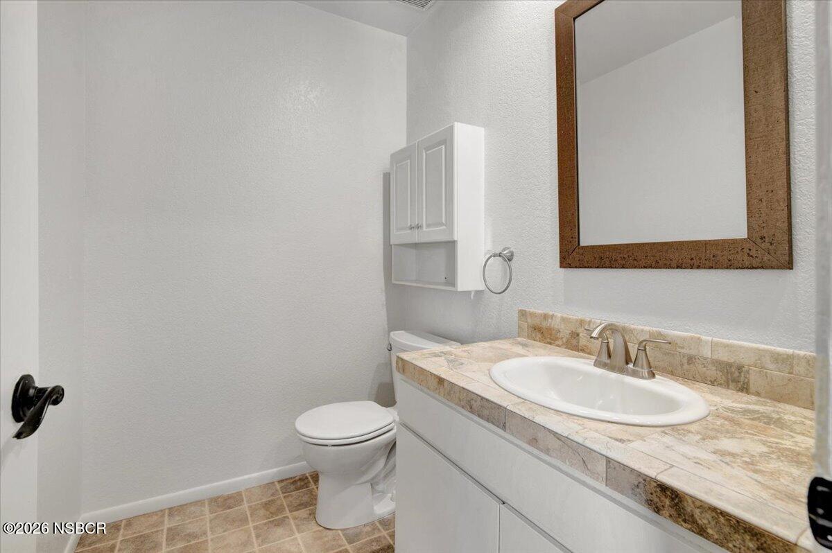 3400 Santa Maria Way, Unit 207B Santa Maria, CA 93455 - Photo 27 of 50 a bathroom with a granite countertop sink a toilet and a mirror