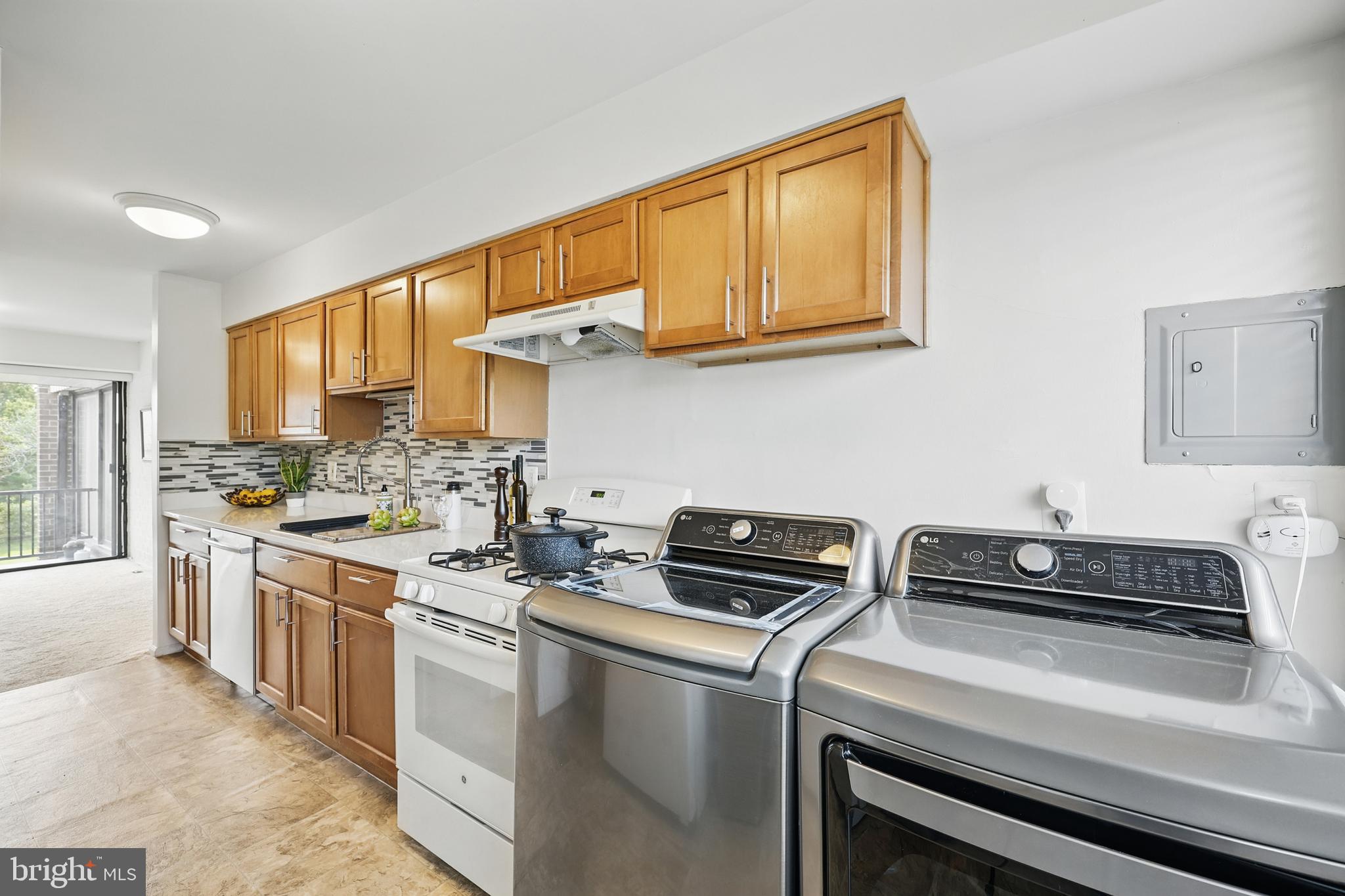 2107 Walsh View Terrace, Unit 14301 & 304 Silver Spring, MD 20902 - Photo 15 of 54 a kitchen with stainless steel appliances a stove a sink dishwasher and cabinets with wooden floor