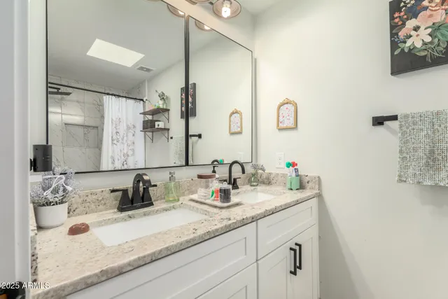a bathroom with a granite countertop sink and a mirror