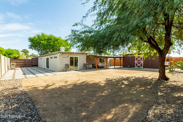 a front view of a house with a yard and tree