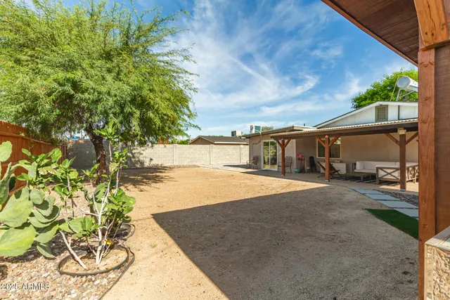 a patio with table and chairs and potted plants