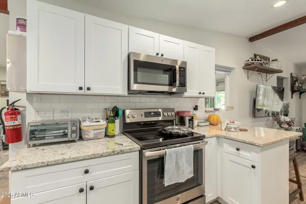 a kitchen with stainless steel appliances granite countertop white cabinets a sink and dishwasher