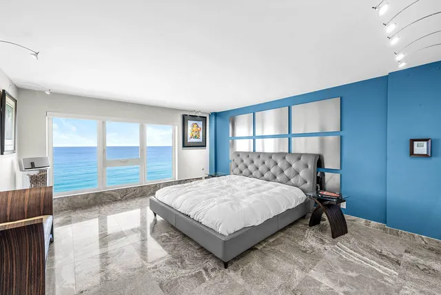 a spacious bedroom with a bed and a painting on the wall