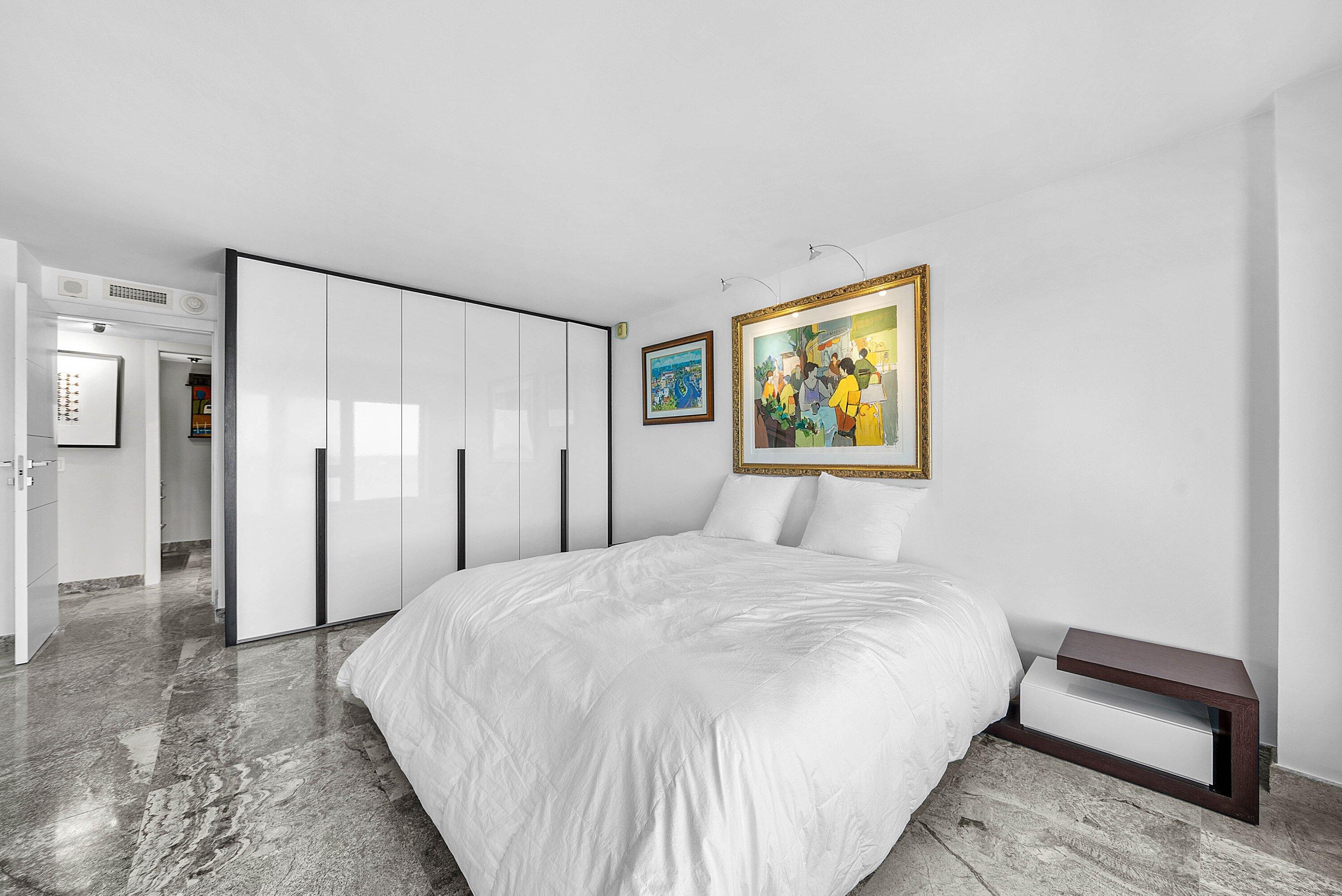 2066 North Ocean Boulevard, Unit 9NE Boca Raton, FL 33431 - Photo 25 of 45 a spacious bedroom with a bed and a painting on the wall