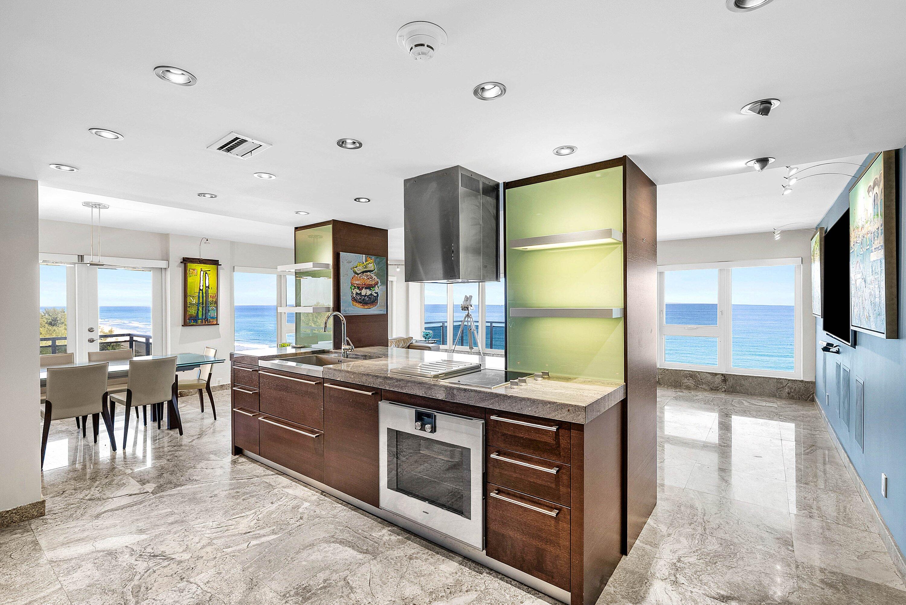 2066 North Ocean Boulevard, Unit 9NE Boca Raton, FL 33431 - Photo 9 of 45 a kitchen with stainless steel appliances granite countertop a stove and a refrigerator