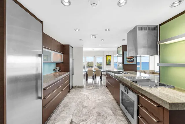 a kitchen with stainless steel appliances granite countertop a refrigerator and a stove