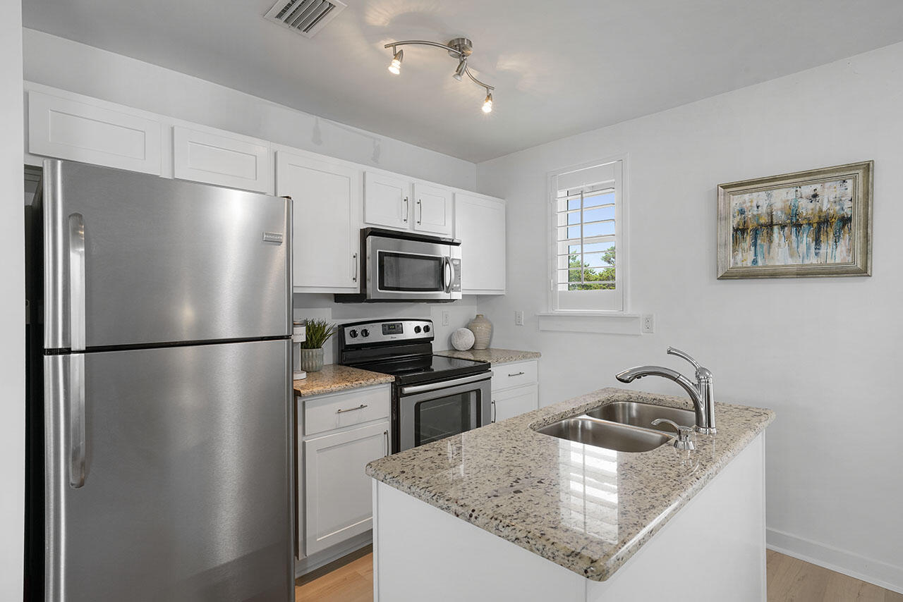 54 Dune Drive Santa Rosa Beach, FL 32459 - Photo 32 of 42 a kitchen with stainless steel appliances granite countertop a refrigerator a sink a stove a microwave and island