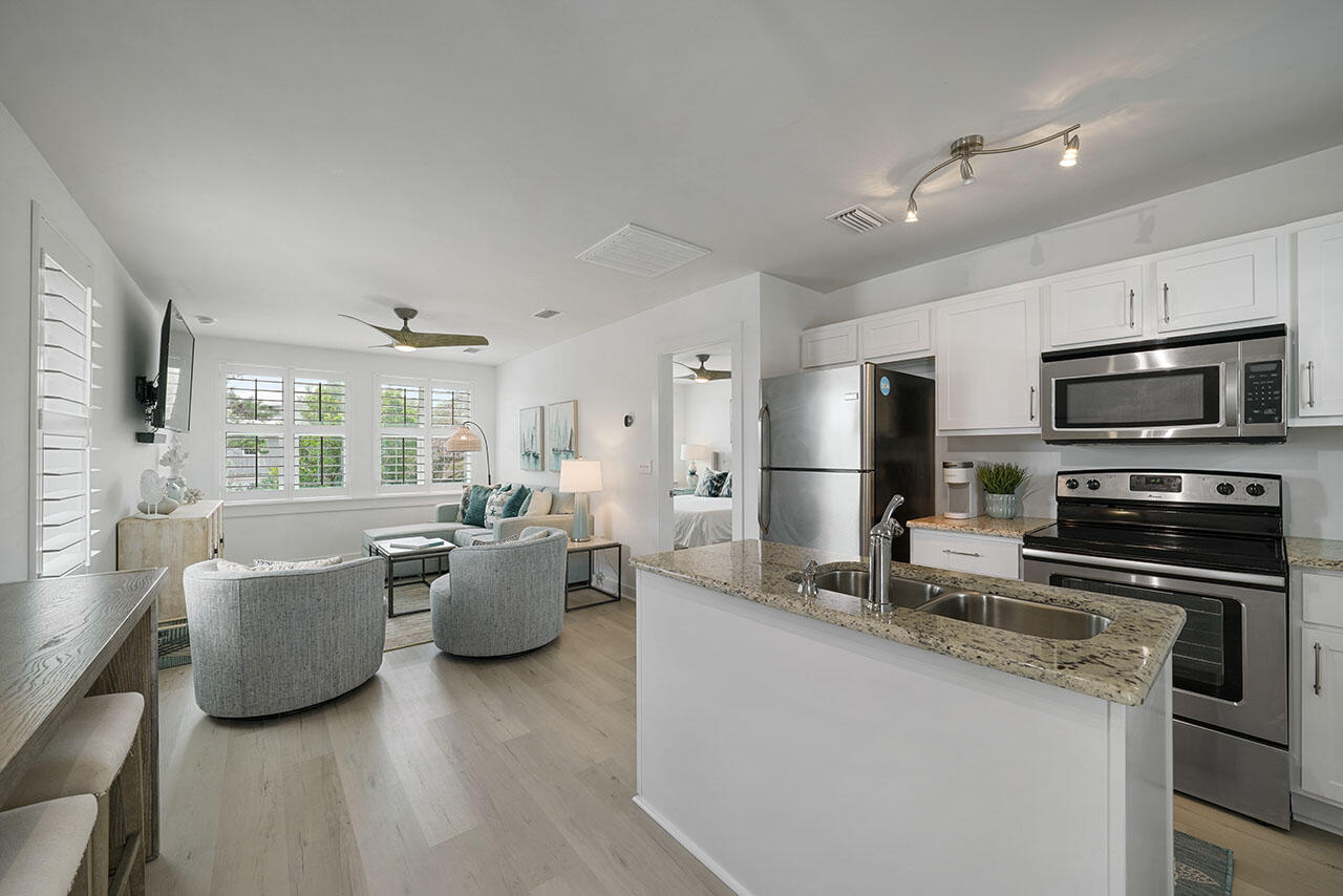 54 Dune Drive Santa Rosa Beach, FL 32459 - Photo 35 of 42 a kitchen with refrigerator a microwave and living room view