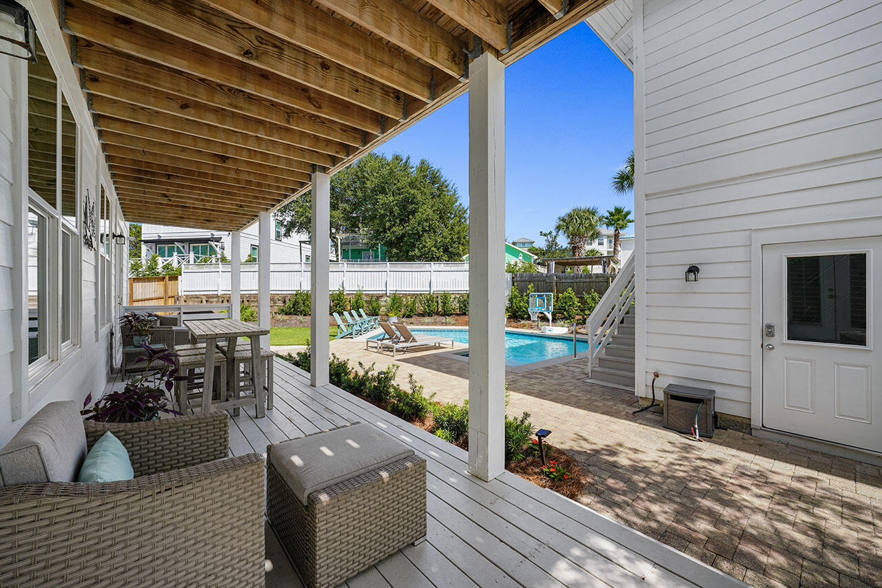 54 Dune Drive Santa Rosa Beach, FL 32459 - Photo 38 of 42 a view of a patio with couches chairs potted plants and floor to ceiling window with wooden floor