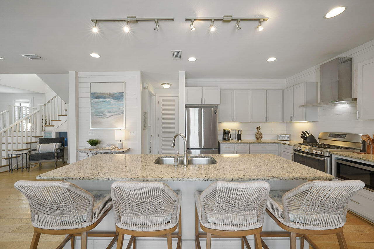 54 Dune Drive Santa Rosa Beach, FL 32459 - Photo 4 of 42 a kitchen with stainless steel appliances kitchen island granite countertop a kitchen island a dining table and chairs
