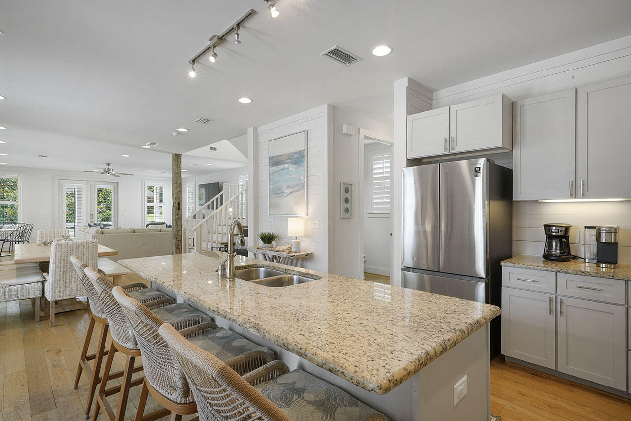 54 Dune Drive Santa Rosa Beach, FL 32459 - Photo 6 of 42 a kitchen with stainless steel appliances granite countertop a table chairs and a refrigerator