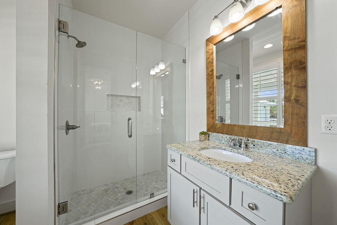 54 Dune Drive Santa Rosa Beach, FL 32459 - Photo 10 of 42 a bathroom with a granite countertop sink a mirror and a shower