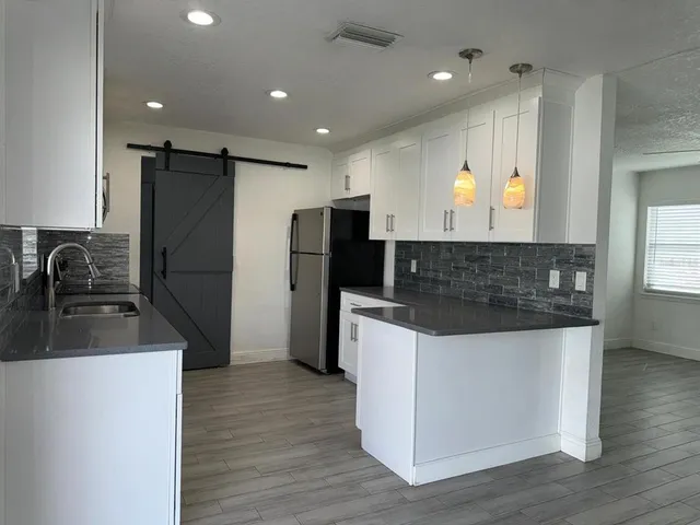a kitchen with stainless steel appliances granite countertop a sink stove and refrigerator