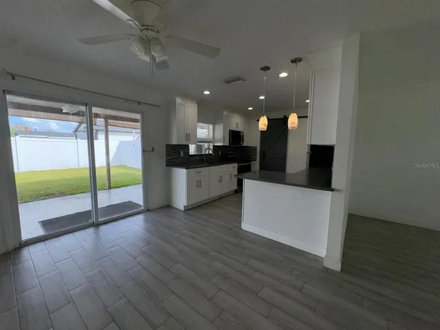a kitchen with stainless steel appliances kitchen island wooden floors and view living room