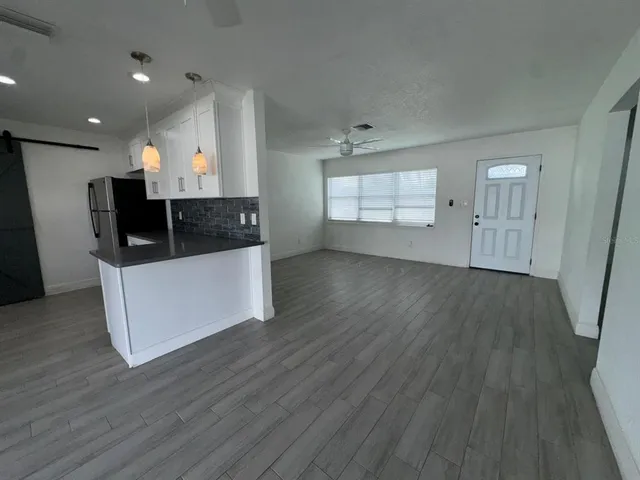 a view of a kitchen with wooden floor and a sink