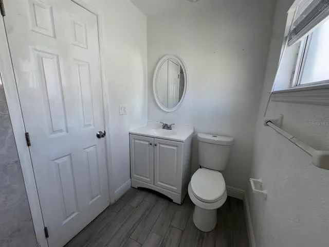 a bathroom with a toilet a sink and a window