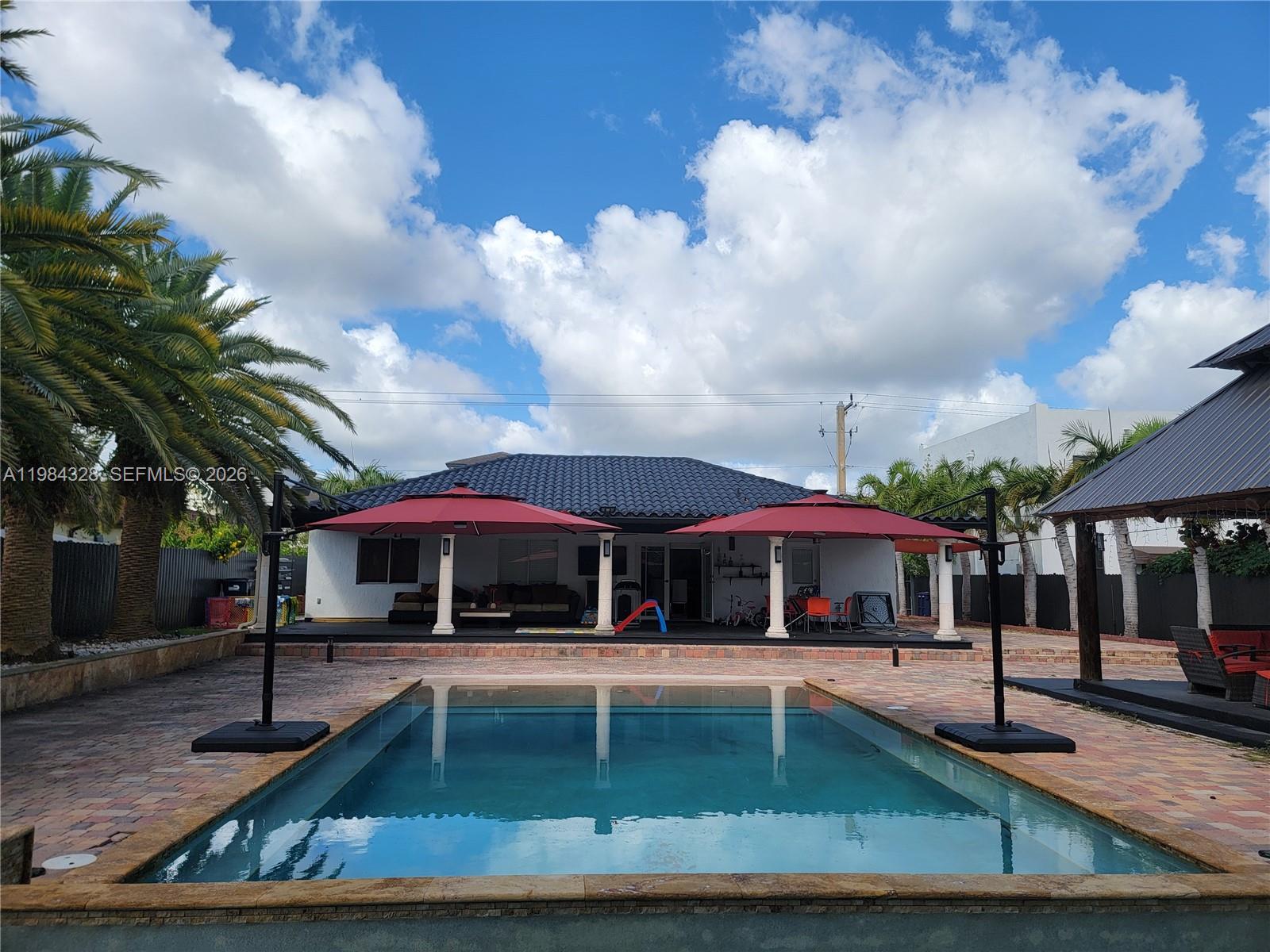25209 Southwest 134th Avenue Homestead, FL 33032 - Photo 26 of 33 a view of a white house with a swimming pool
