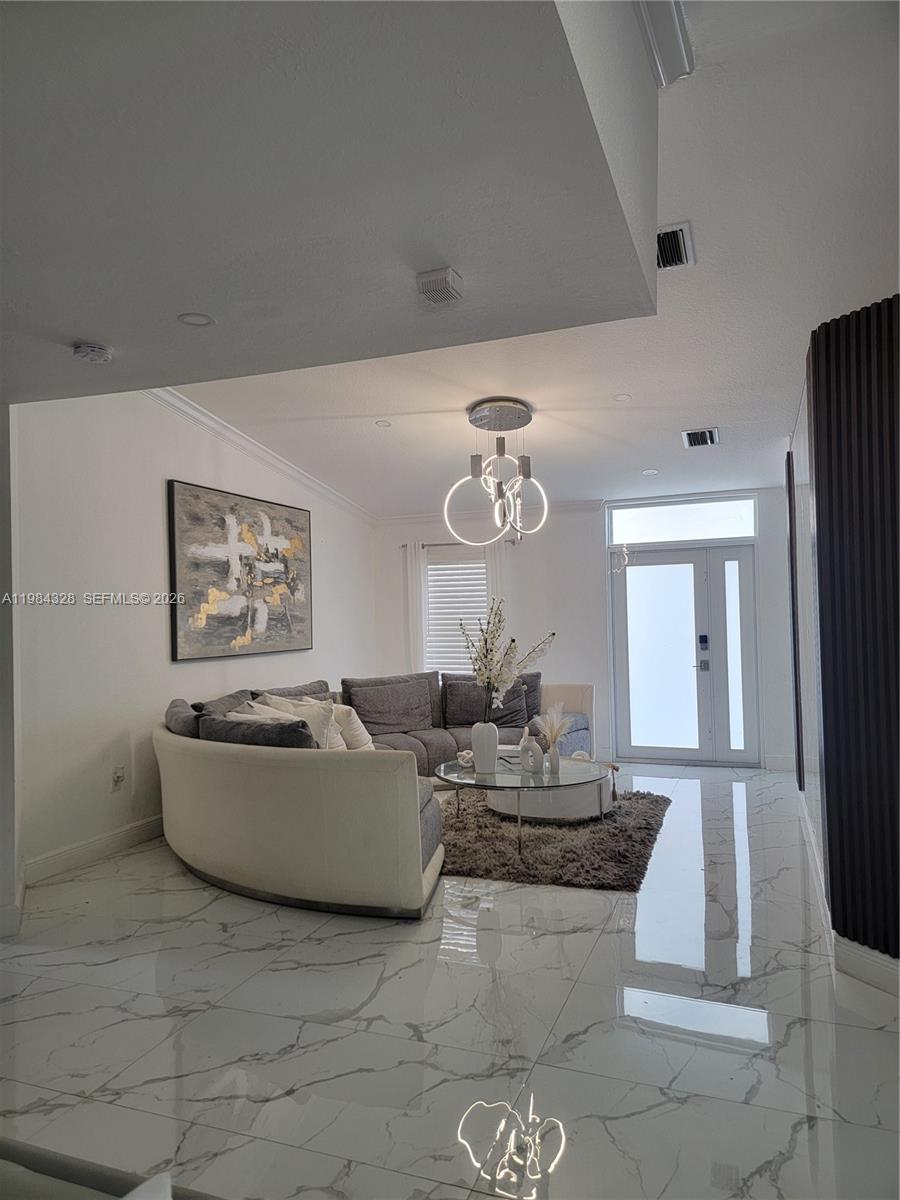 25209 Southwest 134th Avenue Homestead, FL 33032 - Photo 9 of 33 a living room with furniture and a chandelier