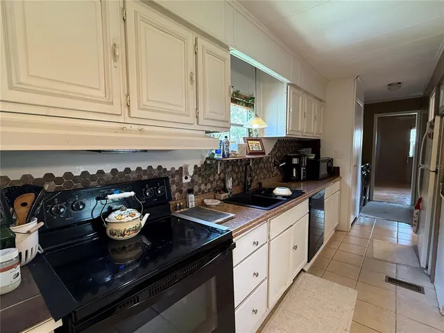 a kitchen with a sink stove and cabinets