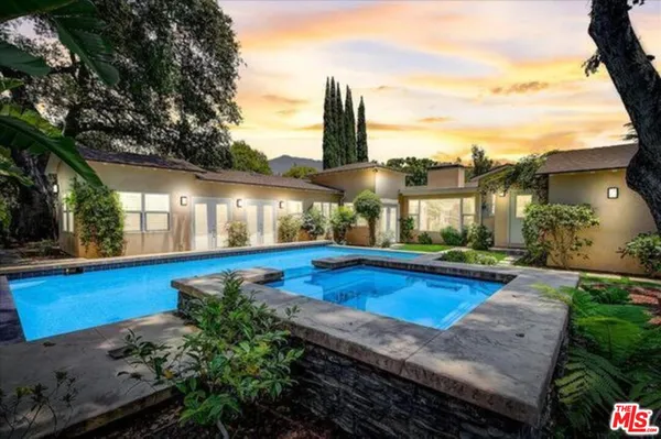 a view of a house with swimming pool and sitting area