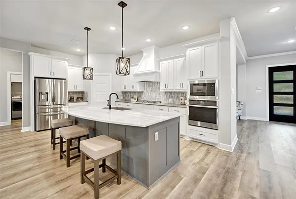 a large kitchen with a large counter top appliances and cabinets