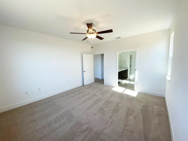 an empty room with a ceiling fan and a window