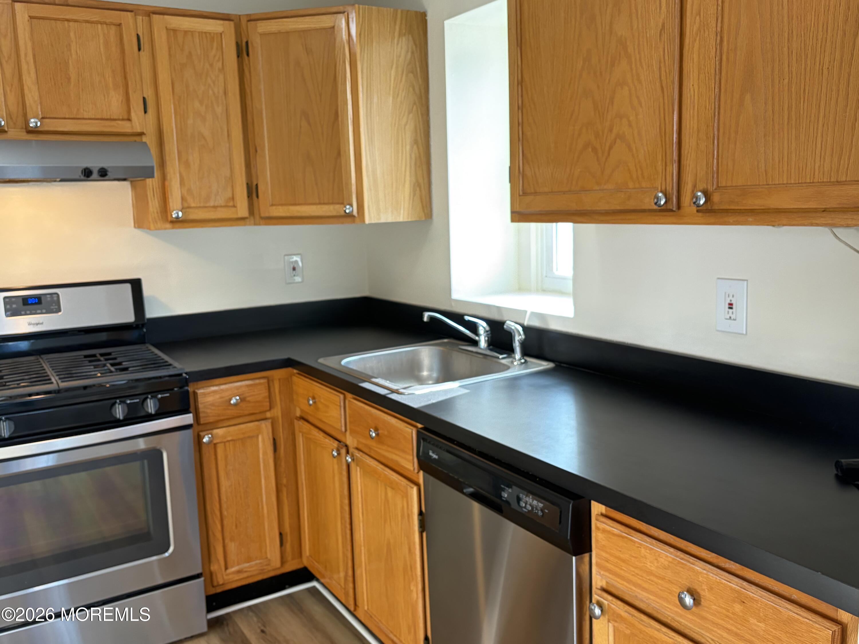 231 Atlantic Street, Unit 33 Keyport, NJ 07735 - Photo 4 of 12 a kitchen with stainless steel appliances a stove a microwave a sink and cabinets