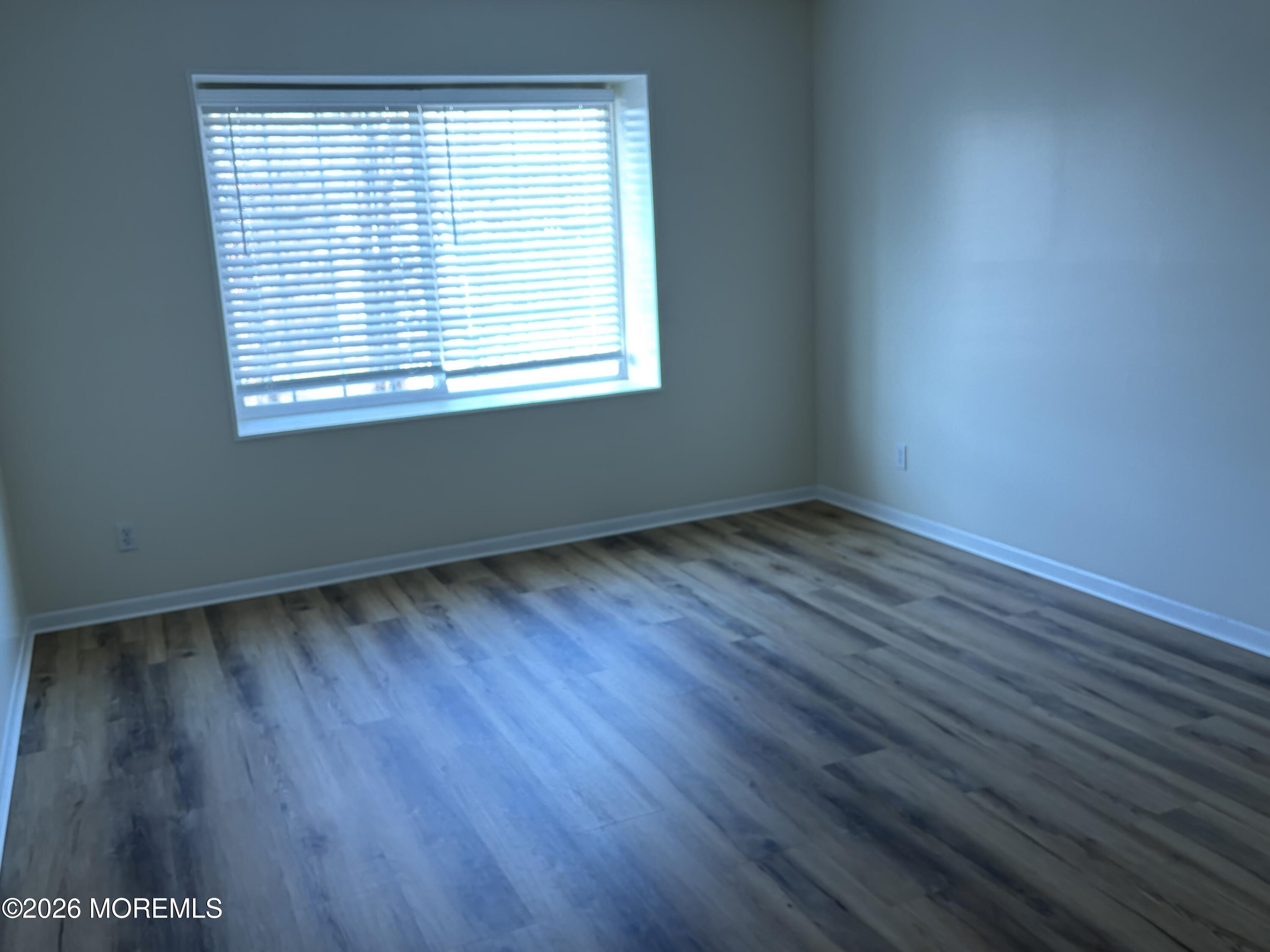 231 Atlantic Street, Unit 33 Keyport, NJ 07735 - Photo 10 of 12 an empty room with wooden floor and windows
