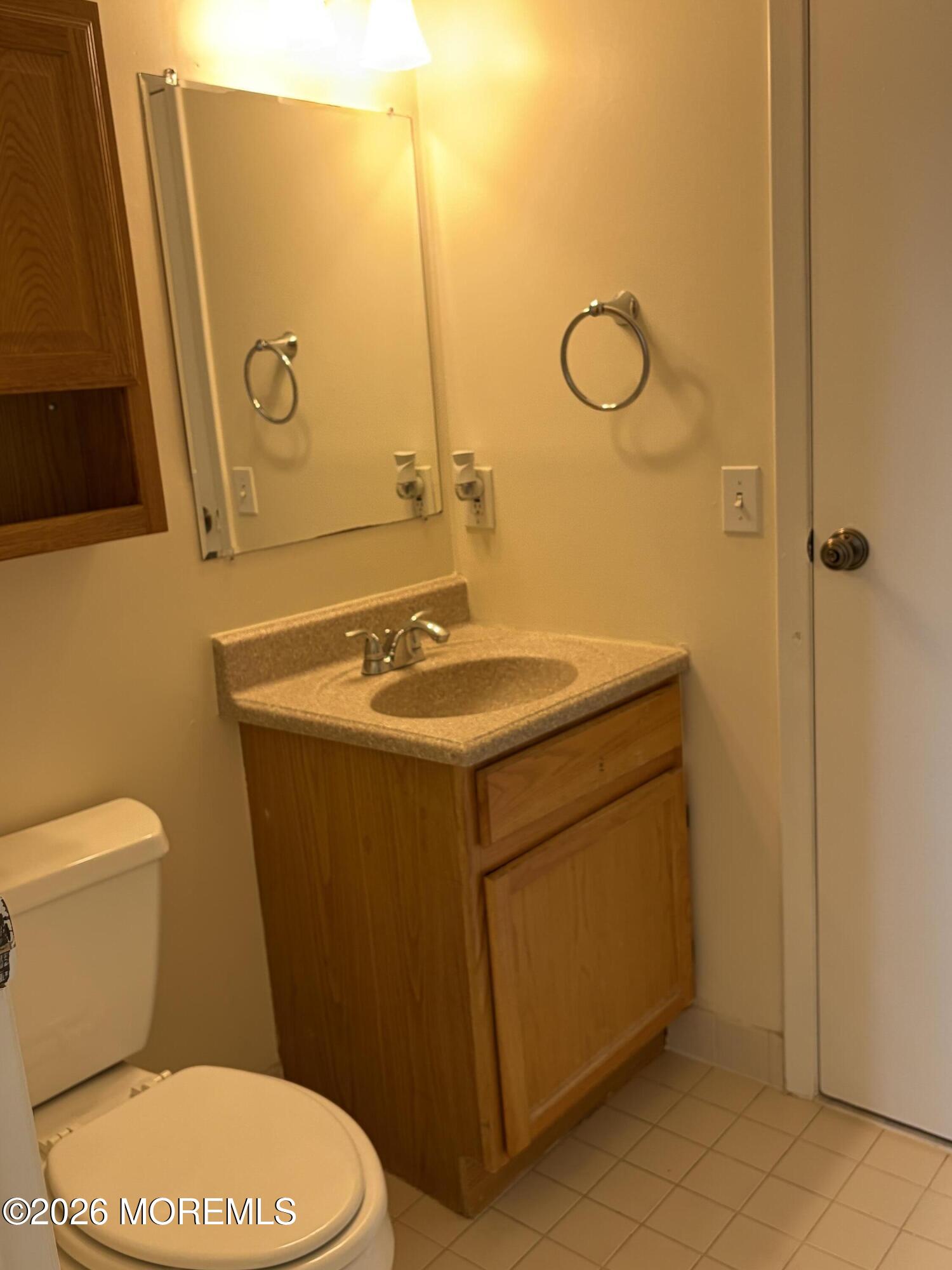 231 Atlantic Street, Unit 33 Keyport, NJ 07735 - Photo 10 of 12 a bathroom with a toilet sink and mirror