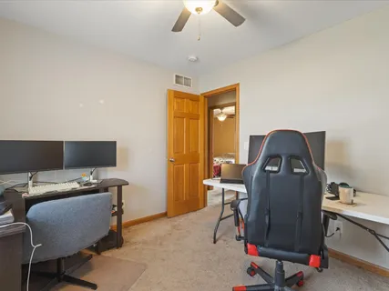 a view of a workspace with furniture and a window