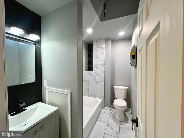 a view of a hallway with wooden floor and living room