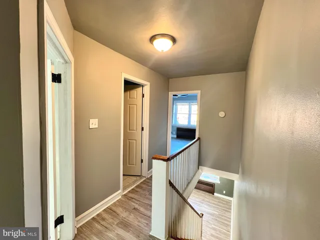 an empty room with wooden floor cabinet and windows