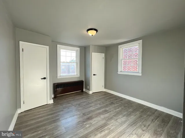 a view of an empty room with wooden floor