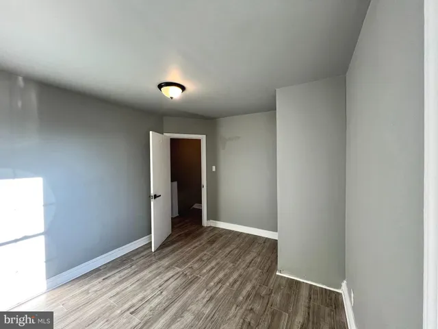 an empty room with wooden floor and a ceiling fan