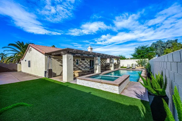 a view of a house with backyard and sitting area