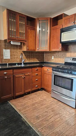 a kitchen with stainless steel appliances granite countertop a stove a sink and a microwave