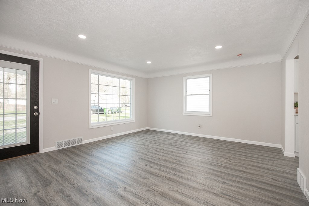 223 Beck Road Avon Lake, OH 44012 - Photo 4 of 29 Unfurnished living room with wood finished floors, visible vents, a healthy amount of sunlight, and baseboards