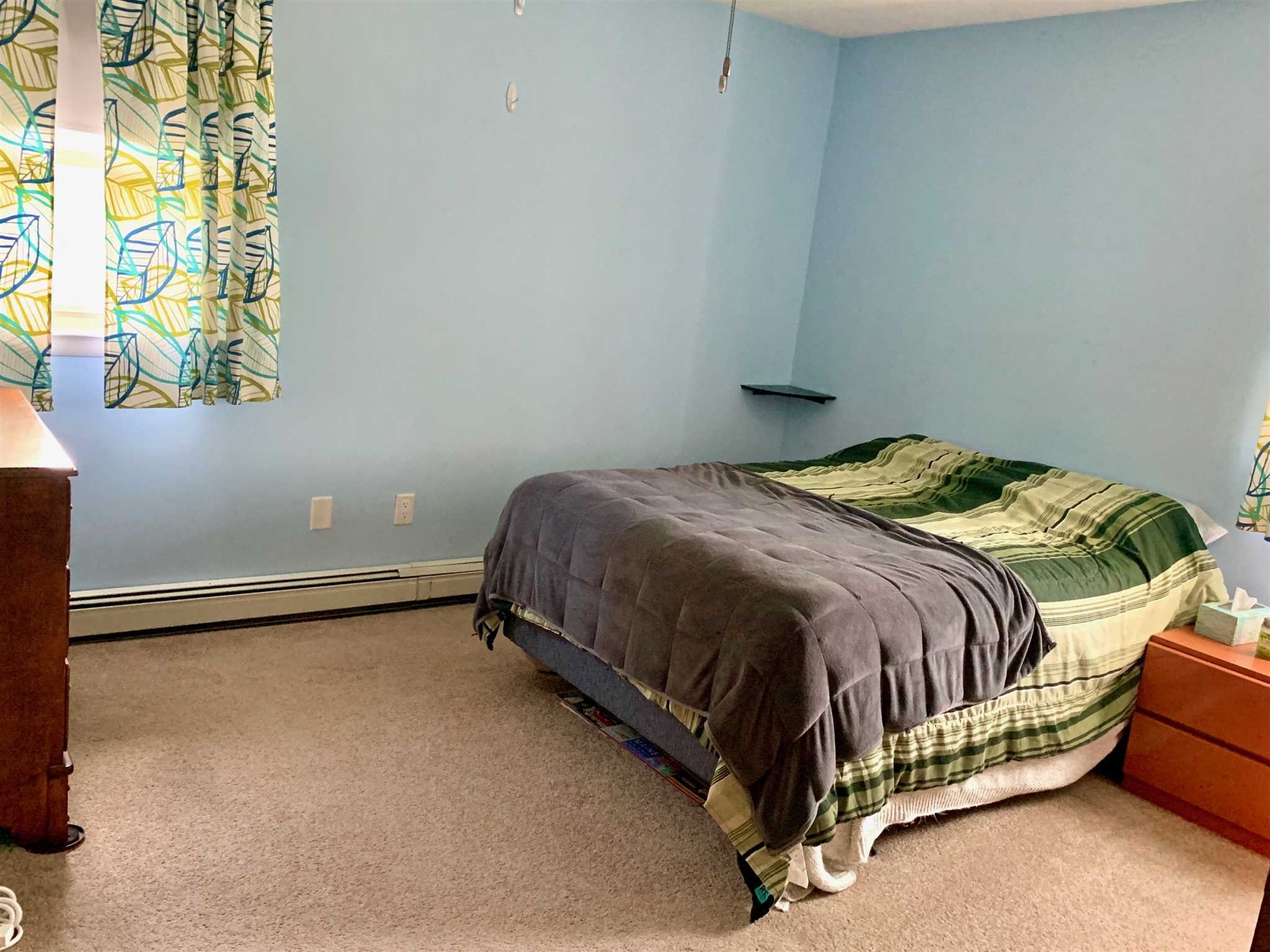 6 Academy Street Beacon, NY 12508 - Photo 13 of 22 a bed sitting in a bedroom next to a blue wall